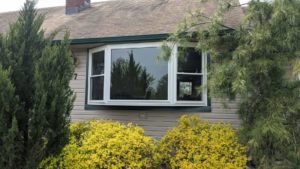 white window with brown roofing of home